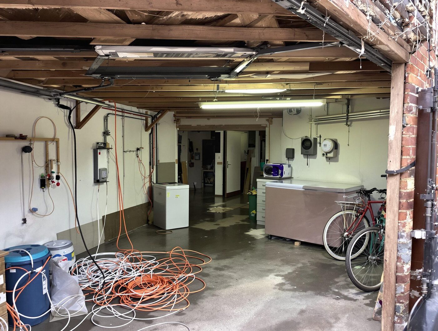 Messy garage with trailing cables and extension leads